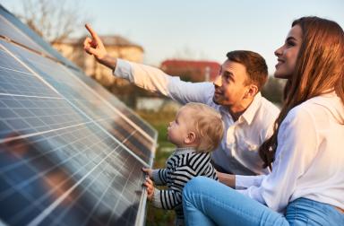 Père de famille qui explique le tarif prosumer devant ses panneaux photovoltaïques