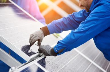 technicien qui installe des panneaux photovoltaiques en Belgique 